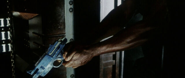 File:Dr. Clauss holds pistol.jpg