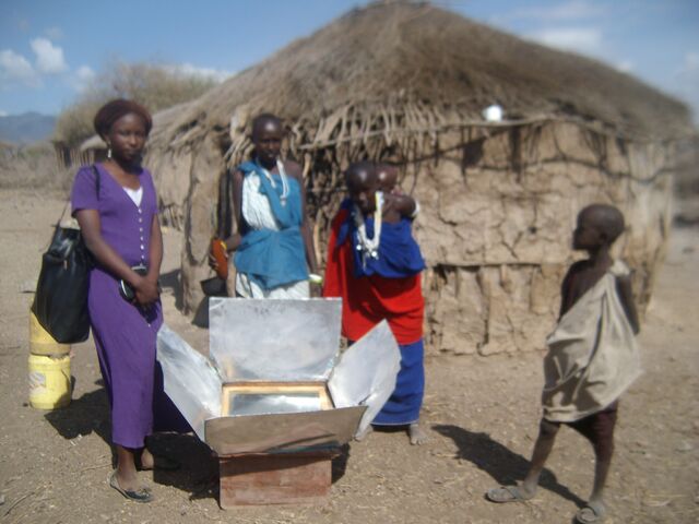 File:Nangai holding the guard with milk ready for cooking outside her house.jpg